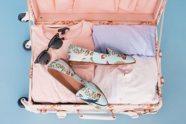 floral suitcase with pink clothes and floral shoes
